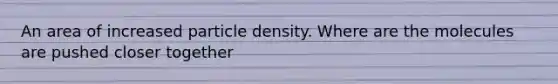 An area of increased particle density. Where are the molecules are pushed closer together