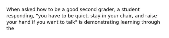 When asked how to be a good second grader, a student responding, "you have to be quiet, stay in your chair, and raise your hand if you want to talk" is demonstrating learning through the