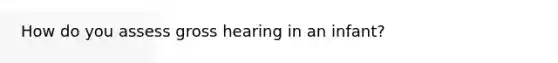 How do you assess gross hearing in an infant?