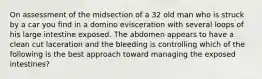 On assessment of the midsection of a 32 old man who is struck by a car you find in a domino evisceration with several loops of his large intestine exposed. The abdomen appears to have a clean cut laceration and the bleeding is controlling which of the following is the best approach toward managing the exposed intestines?