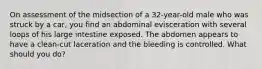 On assessment of the midsection of a 32-year-old male who was struck by a car, you find an abdominal evisceration with several loops of his large intestine exposed. The abdomen appears to have a clean-cut laceration and the bleeding is controlled. What should you do?