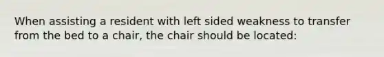 When assisting a resident with left sided weakness to transfer from the bed to a chair, the chair should be located: