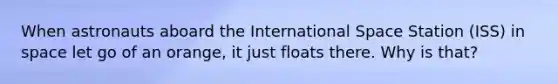 When astronauts aboard the International Space Station (ISS) in space let go of an orange, it just floats there. Why is that?