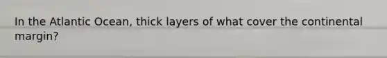 In the Atlantic Ocean, thick layers of what cover the continental margin?