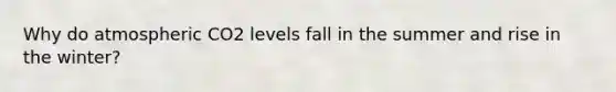 Why do atmospheric CO2 levels fall in the summer and rise in the winter?