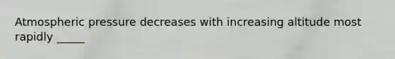 Atmospheric pressure decreases with increasing altitude most rapidly _____