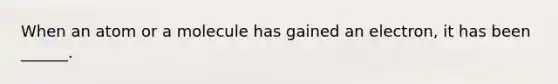 When an atom or a molecule has gained an electron, it has been ______.