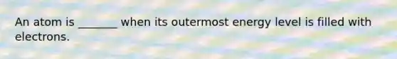 An atom is _______ when its outermost energy level is filled with electrons.