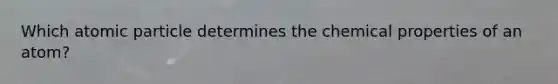 Which atomic particle determines the chemical properties of an atom?