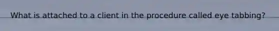 What is attached to a client in the procedure called eye tabbing?