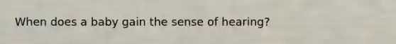 When does a baby gain the sense of hearing?