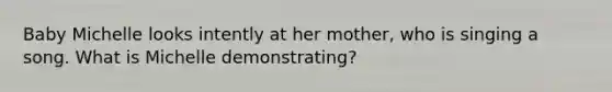 Baby Michelle looks intently at her mother, who is singing a song. What is Michelle demonstrating?