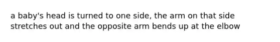 a baby's head is turned to one side, the arm on that side stretches out and the opposite arm bends up at the elbow