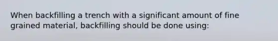 When backfilling a trench with a significant amount of fine grained material, backfilling should be done using: