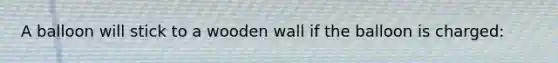 A balloon will stick to a wooden wall if the balloon is charged: