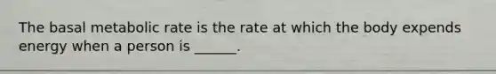 The basal metabolic rate is the rate at which the body expends energy when a person is ______.