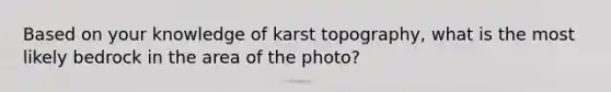 Based on your knowledge of karst topography, what is the most likely bedrock in the area of the photo?