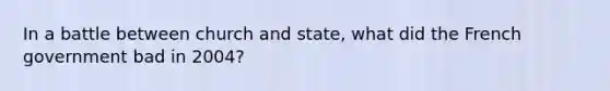 In a battle between church and state, what did the French government bad in 2004?