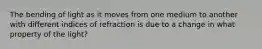 The bending of light as it moves from one medium to another with different indices of refraction is due to a change in what property of the light?