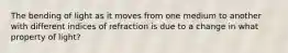 The bending of light as it moves from one medium to another with different indices of refraction is due to a change in what property of light?