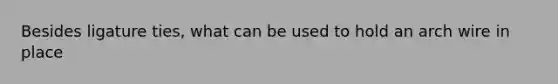 Besides ligature ties, what can be used to hold an arch wire in place