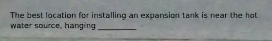 The best location for installing an expansion tank is near the hot water source, hanging __________