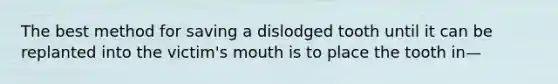 The best method for saving a dislodged tooth until it can be replanted into the victim's mouth is to place the tooth in—