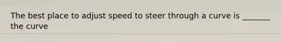 The best place to adjust speed to steer through a curve is _______ the curve
