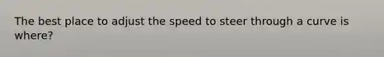 The best place to adjust the speed to steer through a curve is where?