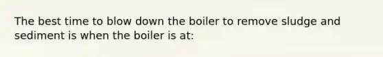 The best time to blow down the boiler to remove sludge and sediment is when the boiler is at: