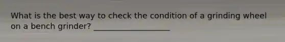 What is the best way to check the condition of a grinding wheel on a bench grinder? ___________________