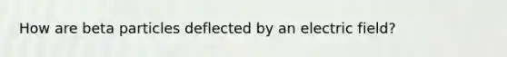 How are beta particles deflected by an electric field?