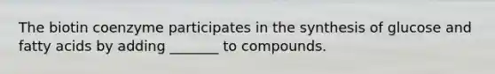 The biotin coenzyme participates in the synthesis of glucose and fatty acids by adding _______ to compounds.