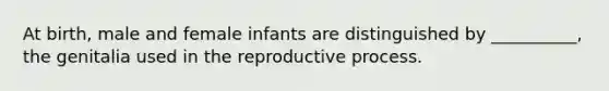 At birth, male and female infants are distinguished by __________, the genitalia used in the reproductive process.​