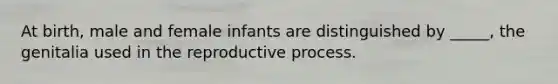 At birth, male and female infants are distinguished by _____, the genitalia used in the reproductive process.