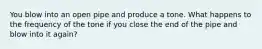 You blow into an open pipe and produce a tone. What happens to the frequency of the tone if you close the end of the pipe and blow into it again?