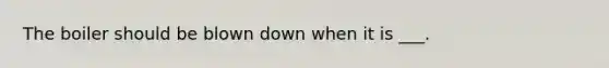 The boiler should be blown down when it is ___.