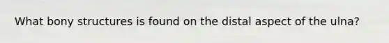 What bony structures is found on the distal aspect of the ulna?