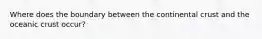 Where does the boundary between the continental crust and the oceanic crust occur?