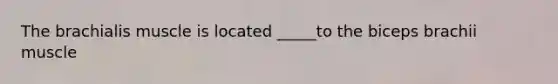 The brachialis muscle is located _____to the biceps brachii muscle