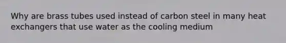 Why are brass tubes used instead of carbon steel in many heat exchangers that use water as the cooling medium