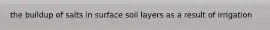 the buildup of salts in surface soil layers as a result of irrigation