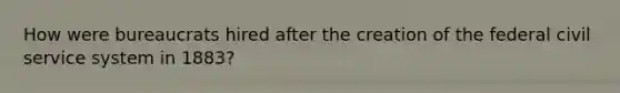 How were bureaucrats hired after the creation of the federal civil service system in 1883?