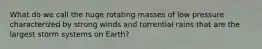 What do we call the huge rotating masses of low pressure characterized by strong winds and torrential rains that are the largest storm systems on Earth?