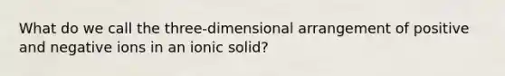 What do we call the three-dimensional arrangement of positive and negative ions in an ionic solid?