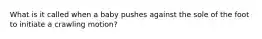 What is it called when a baby pushes against the sole of the foot to initiate a crawling motion?