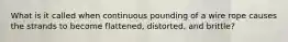 What is it called when continuous pounding of a wire rope causes the strands to become flattened, distorted, and brittle?