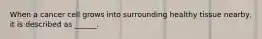 When a cancer cell grows into surrounding healthy tissue nearby, it is described as ______.