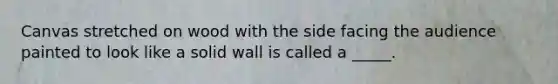 Canvas stretched on wood with the side facing the audience painted to look like a solid wall is called a _____.