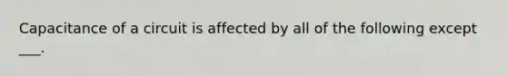 Capacitance of a circuit is affected by all of the following except ___.